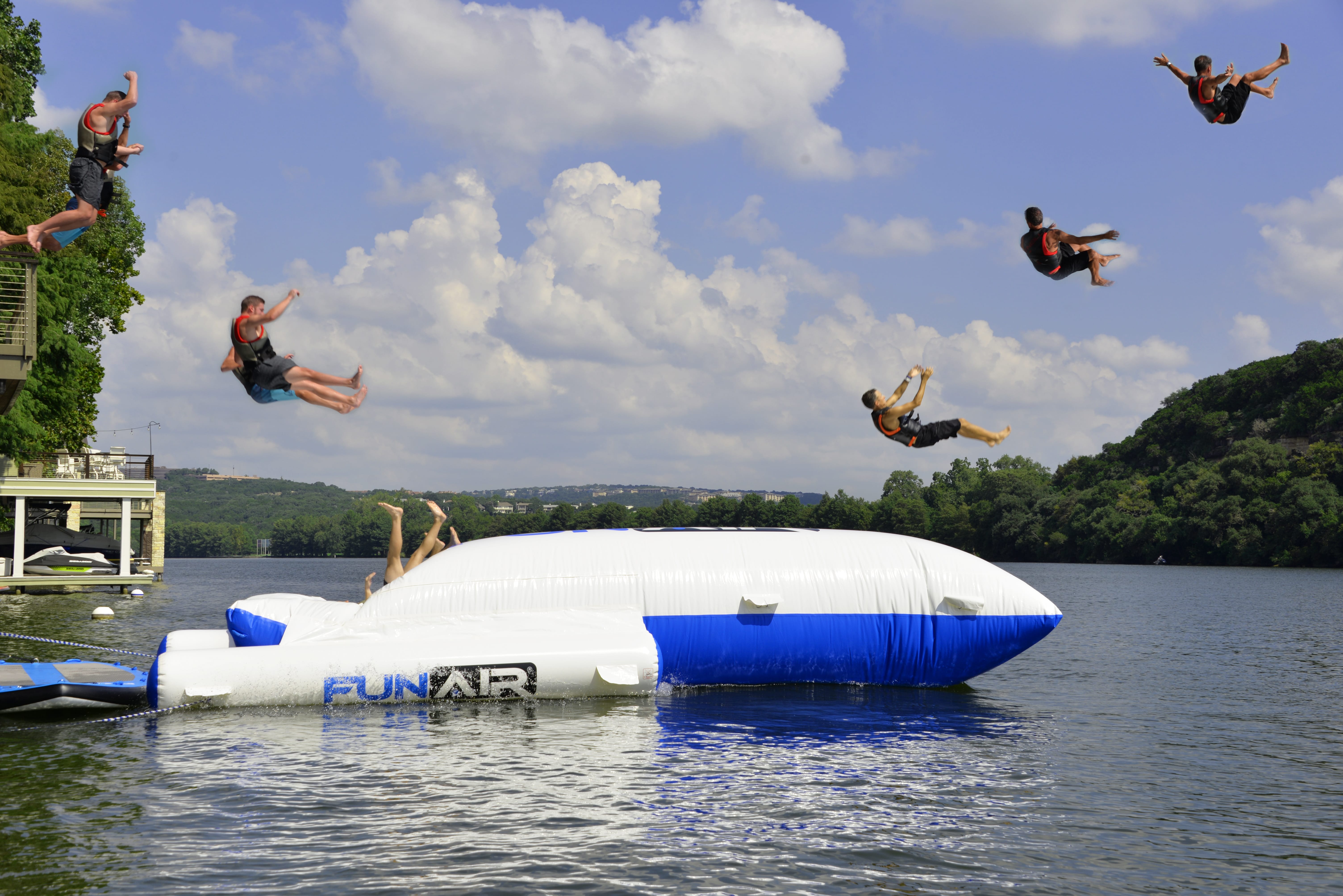 Yacht toys, inflatable air cushion at sea, person jumping onto cushion, catapulting friends into the air