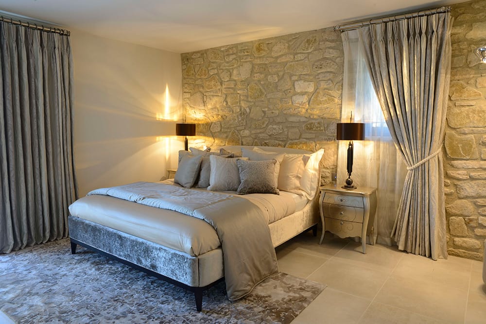 Award winning Provence villa, guest bedroom with honey stone wall, luxury furnishings