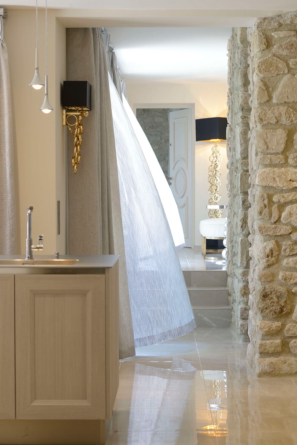 Award winning Provence villa, corridor with stone walls, gloss floor tiles, sheer curtain blowing in the breeze
