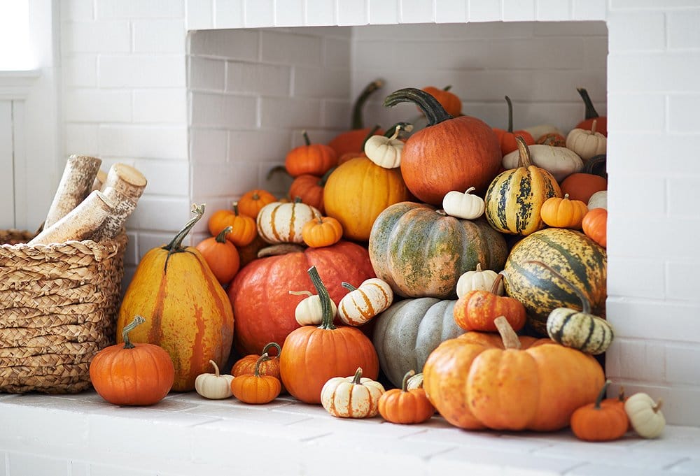 Halloween decor, fireplace full of multi coloured pumpkins